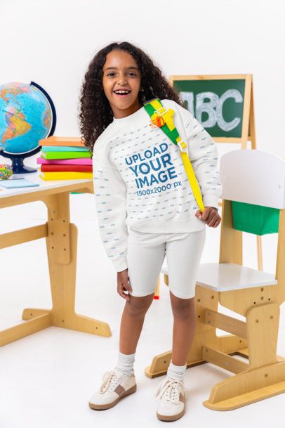Gildan Sweatshirt Mockup of a Smiling Girl Posing Near a School Desk