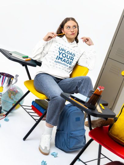 Comfort Colors Hoodie Mockup of a Young Woman Sitting on a School Desk Chair m57178