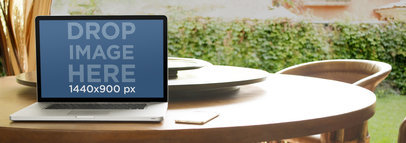 Laptop Mockup Featuring a Macbook Over a Dining Table at the Garden
