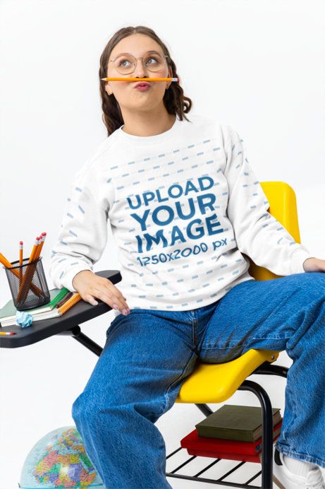 Comfort Colors Sweatshirt Mockup Featuring a Young Woman Making a Funny Pose in a Classroom Set