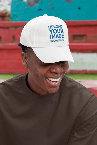 Dad Hat Mockup Featuring a Happy Man With a Small Earring Posing in the Street
