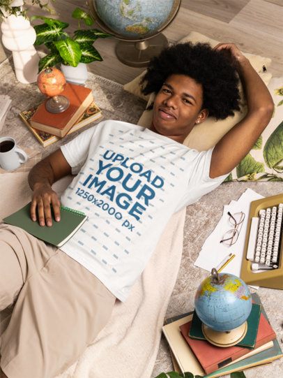 Comfort Colors T-Shirt Mockup of a Man With a Chilly Expression Lying on the Floor With Literature Stuff m56625