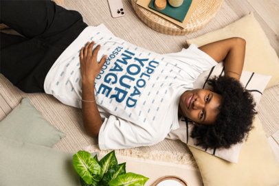 Oversized T-Shirt Mockup Featuring a Smiling Man Relaxing in a Comfy Setting