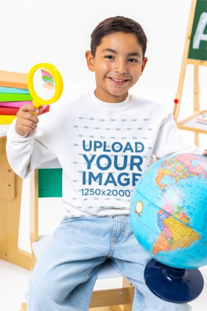 Gildan Sweatshirt Mockup of a Cheerful Kid Holding a Globe and a Loop Glass