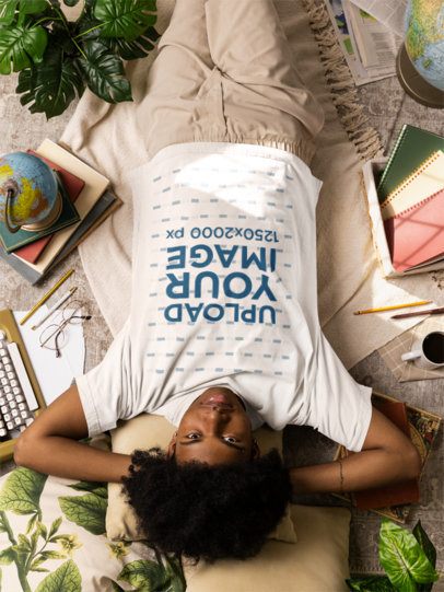 Oversized T-Shirt Mockup Featuring a Serious Man Lying on the Floor With Writing and Literature Stuff m56628