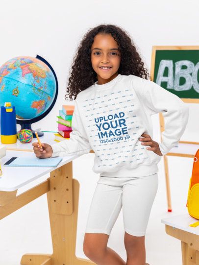 Gildan Sweatshirt Mockup Featuring a Smiling Girl Posing in a School Classroom