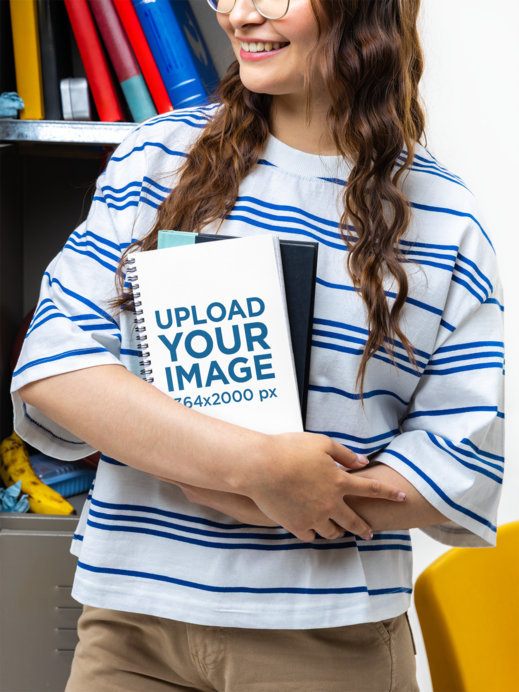 Mockup of a Cropped-Face Happy Young Woman Holding a Notebook in a School Setting