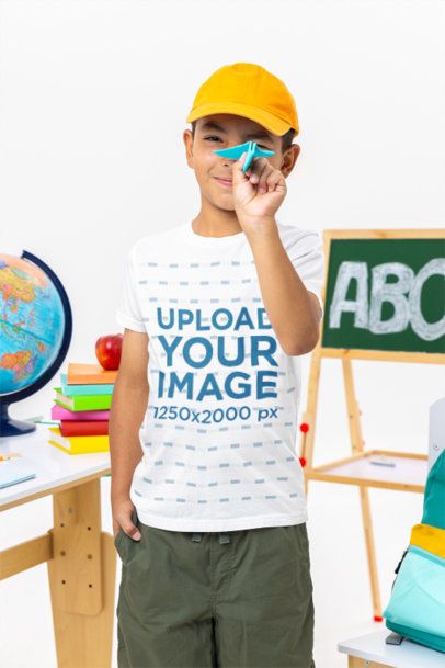Back-To-School Mockup of a Boy in a Bella Canvas Tee Holding a Small Paper Plane