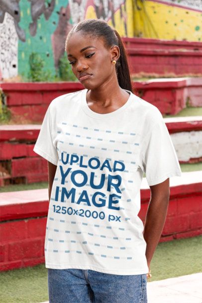 T-Shirt Mockup Featuring a Woman Posing in the Street With a Sad Expression
