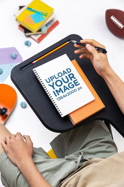 Mockup Featuring a Young Man Sitting on a School Chair Looking at His Notebook m57201
