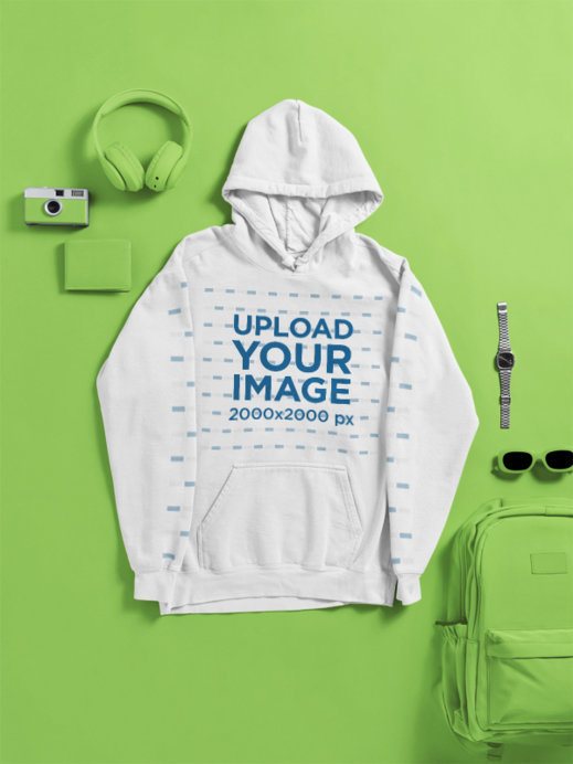 Comfort Colors Mockup Featuring a Hoodie Lying on a Surface With Daily Objects