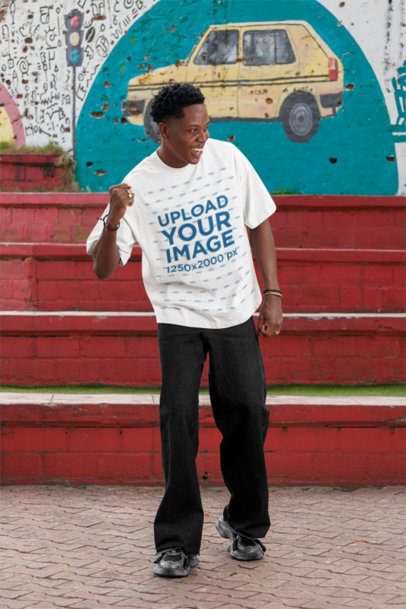 Oversized T-Shirt Mockup of a Cheerful Man Standing by the Street