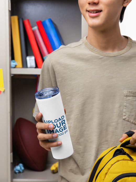 Mockup of a Young Man Student Holding a Skinny Tumbler in a School Classroom Set