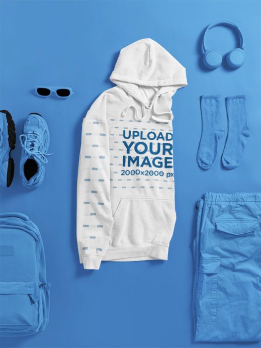 Mockup of a Folded Comfort Colors Hoodie Lying on a Surface With Fitness Clothes