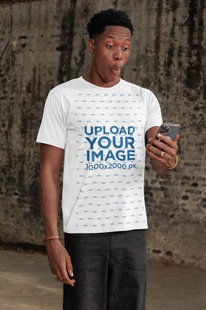 T-Shirt Mockup Featuring a Surprised Man Looking at His Phone in the Street