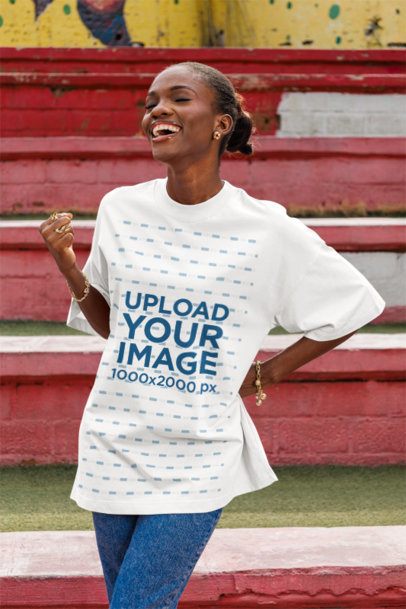 Oversized T-Shirt Mockup Featuring a Joyful Woman Standing in an Urban Setting