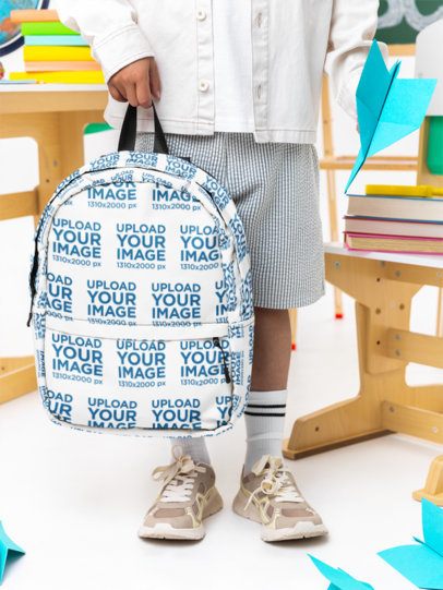 Mockup of a Boy Holding a Backpack and a Paper Plane in a Classroom Setting