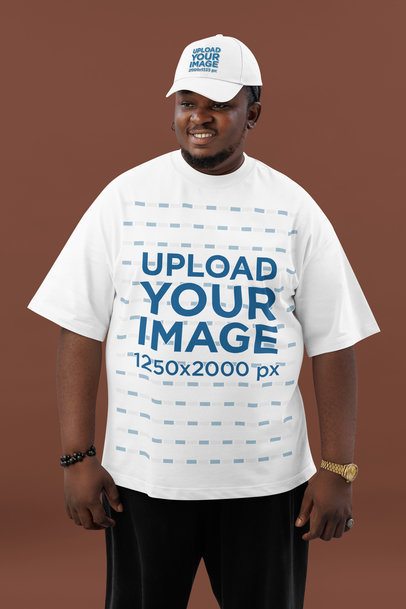 Oversized T-Shirt Mockup Featuring a Bearded Man Wearing an Embroidered Dad Hat in a Studio