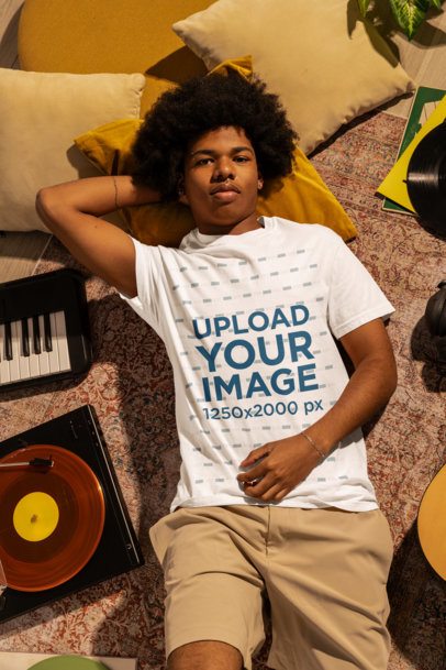 Comfort Colors Tee Mockup Featuring a Man Resting on the Floor Surrounded by Music Stuff m56617