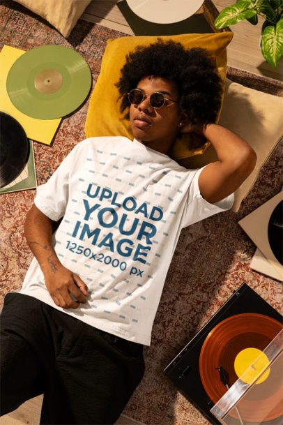 Oversized T-Shirt Mockup of a Man Lying on the Floor With Music Albums m56619