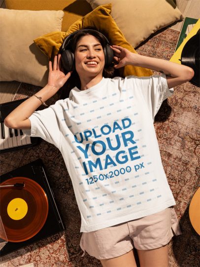 Oversized T-Shirt Mockup Featuring a Happy Woman Chilling and Listening to Music
