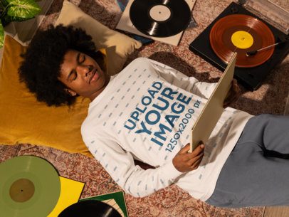 Comfort Colors Mockup of a Man in a Long-Sleeve Tee Resting on the Floor and Holding a Music Album m56622