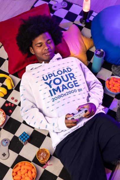 Comfort Colors Hoodie Mockup of a Smiling Man Playing Video Games in a Comfy Spot m56630