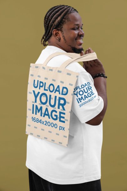 Oversized T-Shirt Mockup Featuring a Happy Man Carrying a Tote Bag on His Shoulder