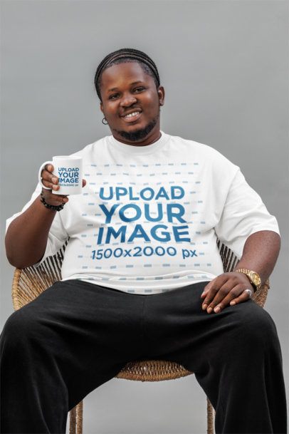 Oversized T-Shirt Mockup Featuring a Happy Man Sitting on a Chair With a Coffee Mug