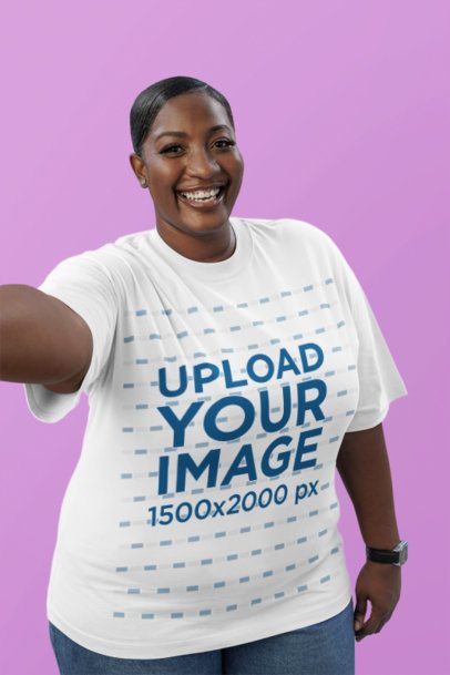 Oversized T-Shirt Mockup of a Cheerful Woman Taking a Selfie in a Colorful Studio Background