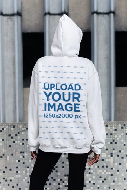 Back-View Mockup of a Woman in a Pullover Hoodie Standing on the Sidewalk