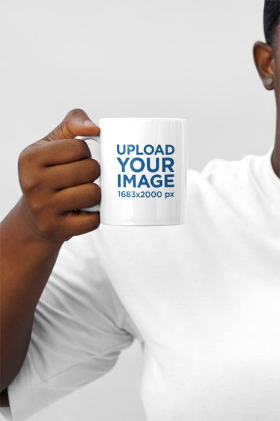 Mockup of a Woman Holding a Sublimated Coffee Mug in a Studio Setting