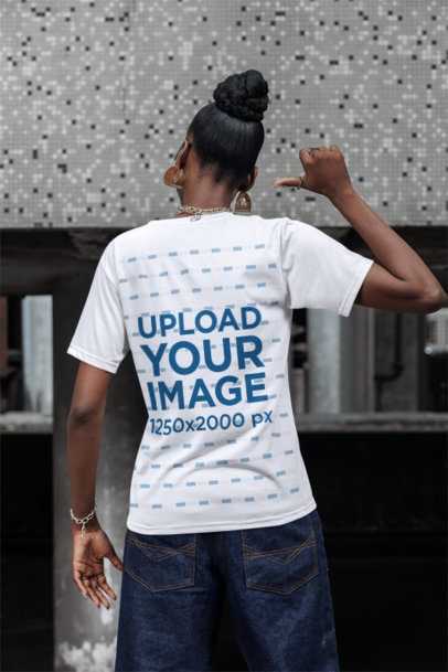 Back-View Mockup Featuring a Woman Pointing at Her T-Shirt on the Sidewalk
