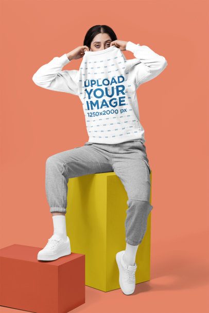 Comfort Colors Mockup of a Woman Sitting in a Colorful Cube While Covering Her Face With a Sweatshirt m57423