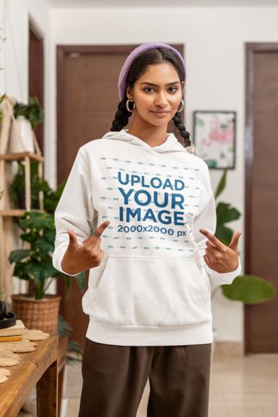 Mockup of a Woman Pointing at Her Pullover Hoodie in a Nice Homemade Setting m55431
