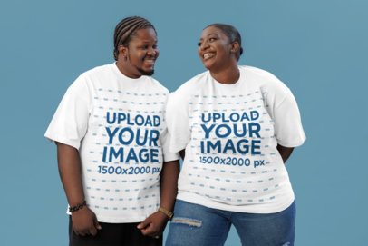 Oversized T-Shirt Mockup Featuring a Cheerful Man and a Woman Standing Against a Colorful Setting