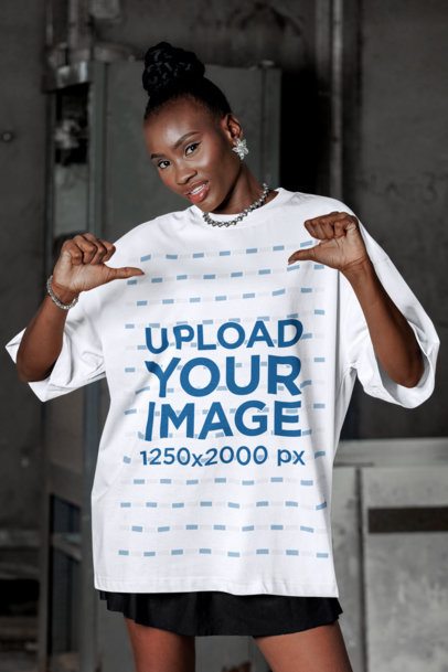 Mockup of a Woman Pointing at Her Oversized T-Shirt While Posing in a Parking Lot
