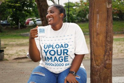 Coffee Mug Mockup Featuring a Cheerful Woman Wearing an Oversized Tee in the Park