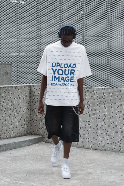 Mockup of a Man Wearing an Oversized T-Shirt While Walking With Headphones