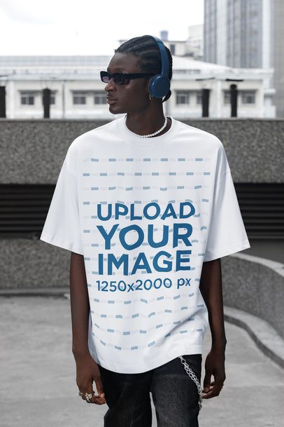 Oversized T-Shirt Mockup Featuring a Man With Headphones Standing by the Street