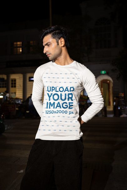 Bella Canvas Mockup Featuring a Man in a Long-Sleeve Tee Posing in a Street by Night m56880