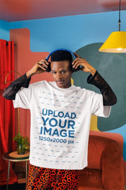 Oversized T-Shirt Mockup of a Cool Man in Headphones Posing in a Colorful Living Room