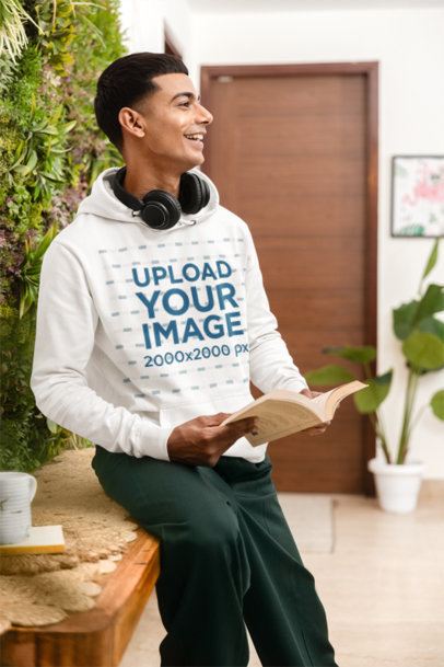 Pullover Hoodie Mockup Featuring a Smiling Man With Headphones on His Neck Holding a Book m55434