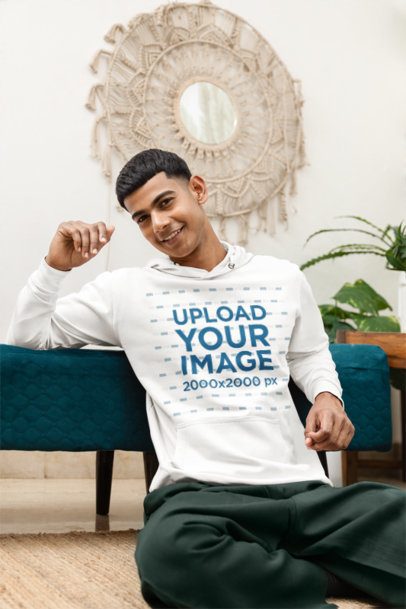 Pullover Hoodie Mockup of a Happy Man Sitting on the Floor in a Cozy Spot m55428