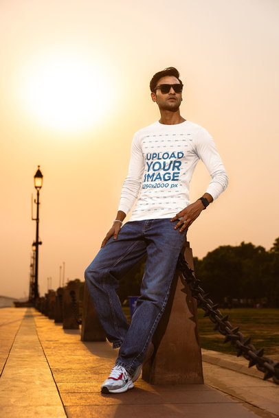 Bella Canvas Mockup of a Man in a Long-Sleeve Tee Posing on a Bridge Against a Sunset View m56792