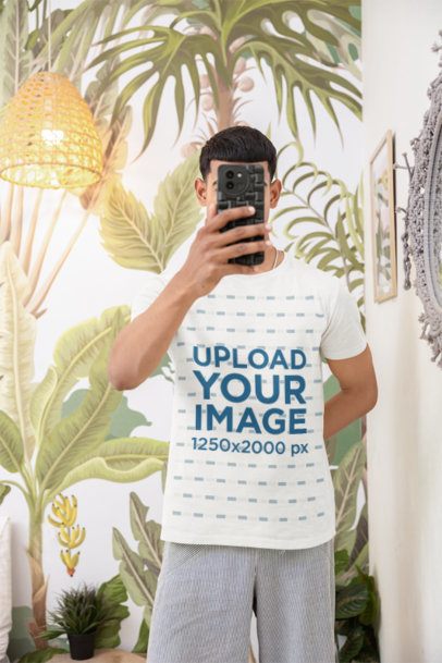 Round-Neck T-Shirt Mockup Featuring a Man With a Phone Posing Against a Painted Wall  m55420