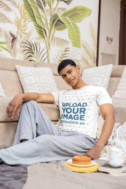 T-Shirt Mockup of a Smiling Man Sitting on the Floor in a Cozy and Warm Living Room m55417