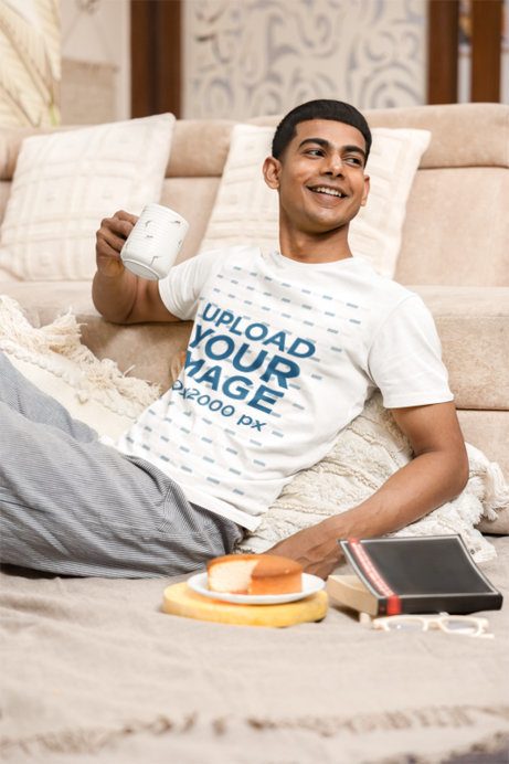 T-Shirt Mockup Featuring a Cheerful Man Drinking Coffee in a Cozy Living Room