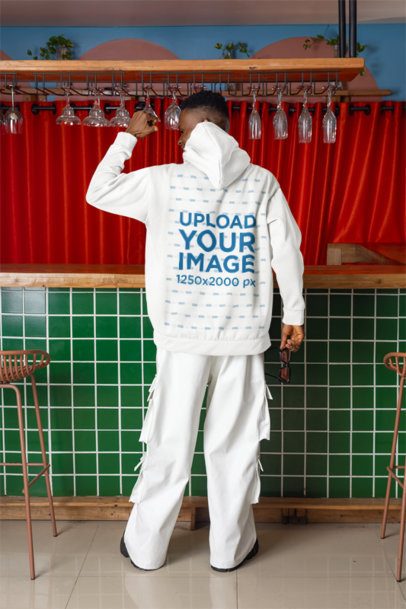 Back-View Mockup Featuring a Man Pointing at his Pullover Hoodie in a Bar