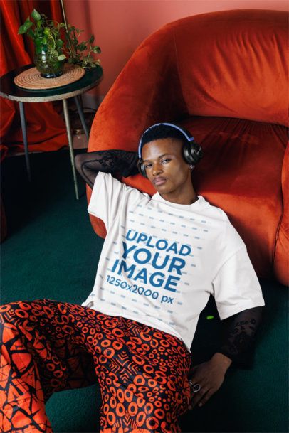Oversized T-Shirt Mockup Featuring a Serious Man With Headphones Posing in a Living Room